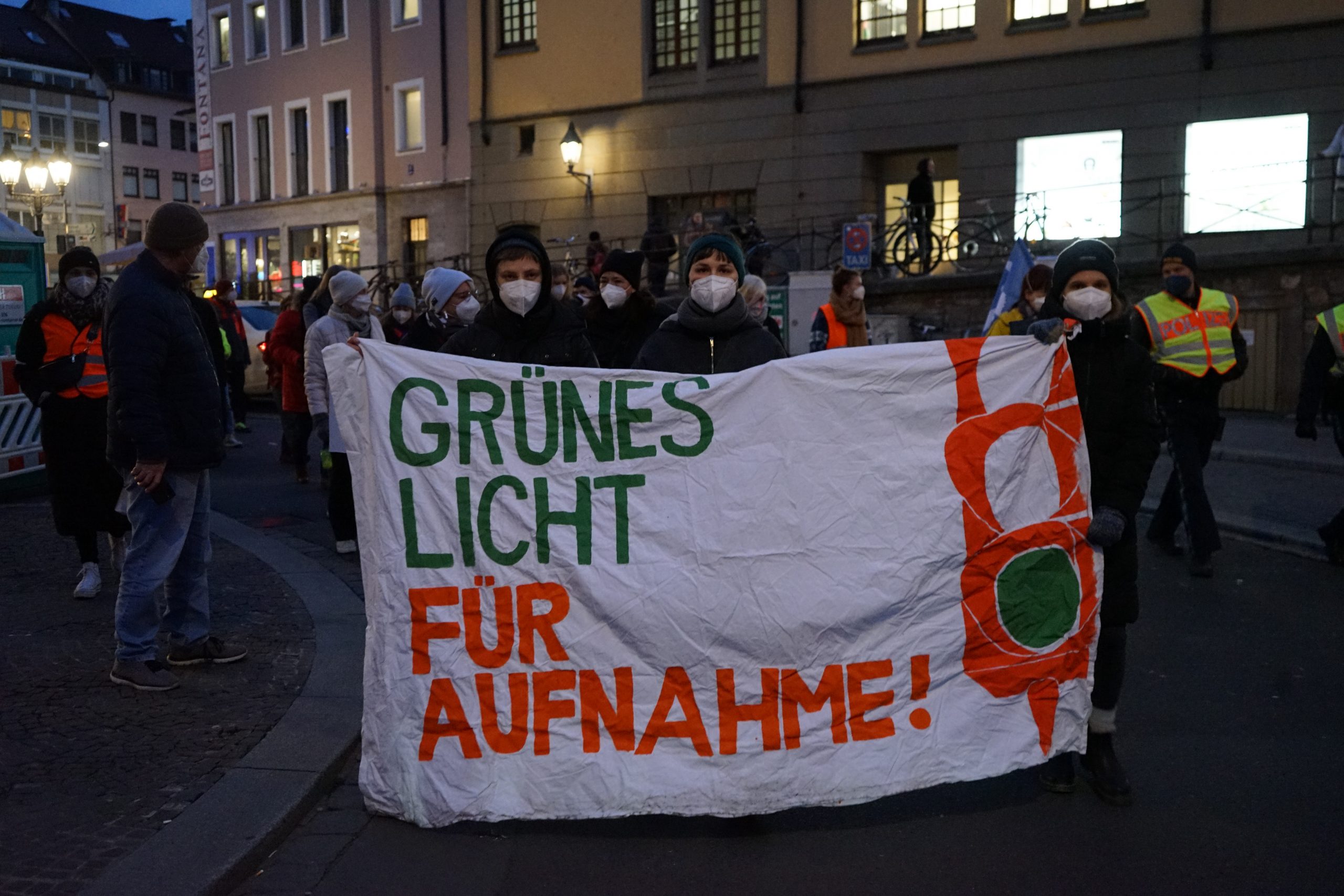 Ein Demonstrationszug, in dem man ein Banner mit der Aufschrift "Grünes Licht für Aufnahme!" sehen kann.